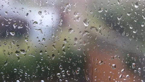 Heavy rain hitting window with droplets running down it. Stormy day. Stock Footage 176387985