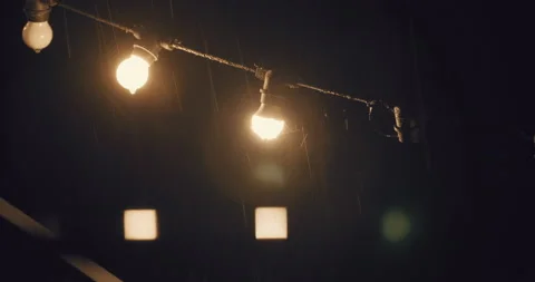 Heavy rain at night with decoration string lights hunging on backyard. Stock Footage 224745362
