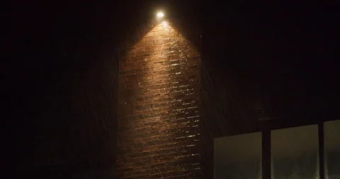 Heavy rain at night with visible raindrops and lightning flashes in light Stock Footage 329839827