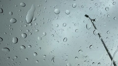 Heavy rain on a parked car windshield with raindrops and a streetlight outside. Stock Footage 345838782