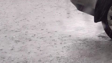 Heavy rain in the parking lot. The lower part of the car and the rear wheel are  Stock Footage 155692829