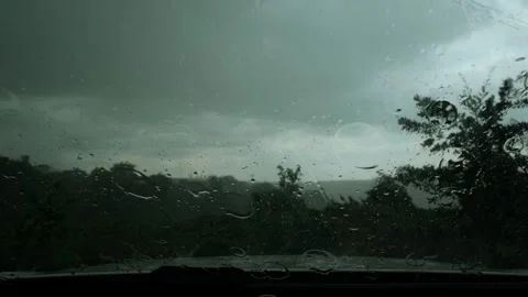 Heavy rain pouring on car windshield during dark stormy weather A close-up .. Video stock 341324176