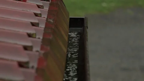 Heavy Rain Pouring Down on Red Metallic Roof of House. Gutter During Rainy .. Stock Footage 330126074