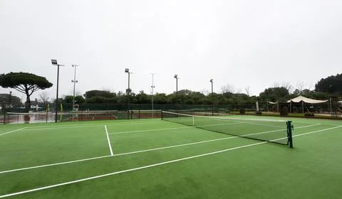Heavy rain pours down on empty tennis courts, soaking the surface and disto.. Stock Photos
