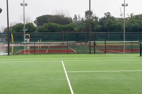 Heavy rain pours down on empty tennis courts, soaking the surface and disto.. 스톡 사진