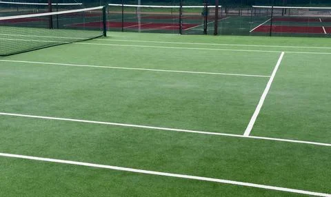 Heavy rain pours down on empty tennis courts, soaking the surface and disto.. Stockfoto's