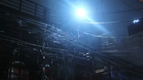 Heavy rain pours over chaotic city power lines in Manila night scene Stock Footage 332667529