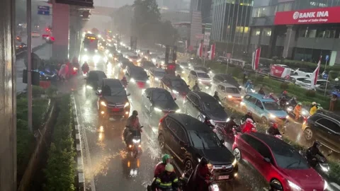 Heavy rain pours over a congested city street filled with cars stuck in traffic. 库存影片 333838581