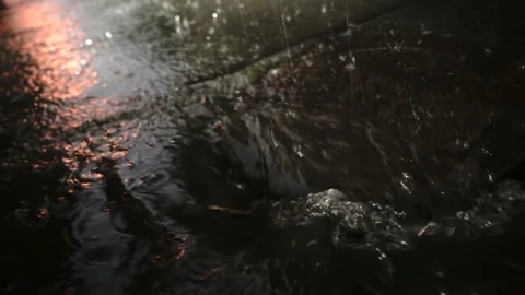Heavy rain Rainwater flows on the road and fall into the metal hatch - 4K  Stockbeeldmateriaal 148706139
