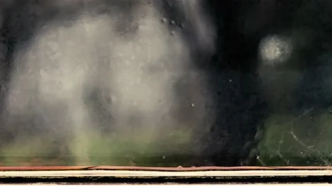 Heavy rain seen from inside a home to a suburban street as defocused background. Stock Footage 146515551