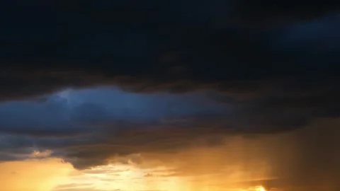 A heavy rain shafts across a dramatic sunset sky timelapse video. Video stock 337362512