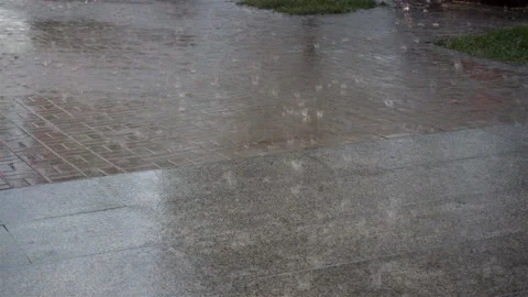 Heavy rain on the sidewalk in 4K. Stock Footage 130875277