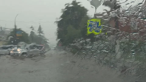 Heavy rain splattering on a car windshield during a storm Stock Footage 338409372