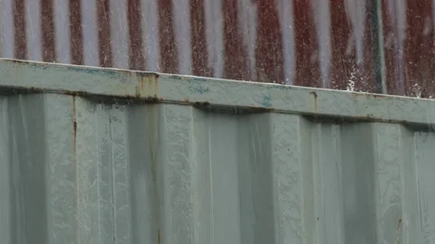 Heavy rain splattering on top of a rusty metal container. Stock Footage 338365381