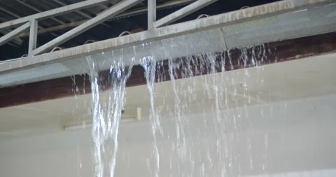 A heavy rain storm caused the gutter to overflow and cause water to flow out. Stock Footage 222619751