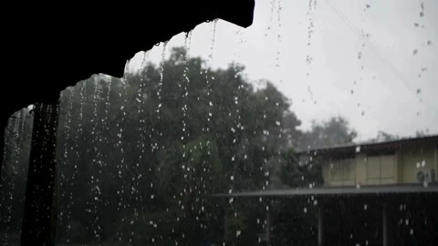 Heavy rain thunderstorm water dripping from roof of a house in day time. 스톡 동영상 336570996