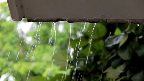 Heavy rain thunderstorm water dripping from roof of a house in day time. Stock Footage 336571041