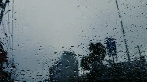 Heavy Raindrops Falling on Car Windshield While Driving in City Traffic Vídeos de archivo 321398300