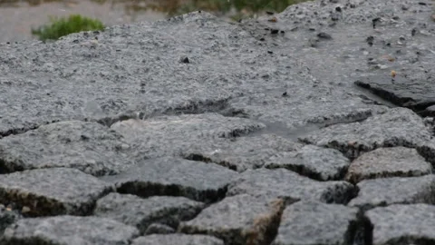 Heavy raindrops falling on a wet stone ground during a downpour Stock Footage 329557435
