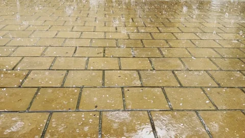 Heavy raindrops with hail fall on the paving slabs. Stock Footage 243254633