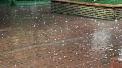 Heavy raindrops with hail fall on the paving slabs. Slow motion video. Video stock 248382222