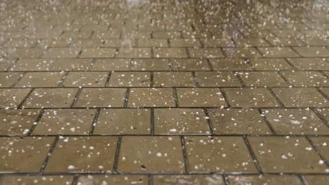 Heavy raindrops with hail fall on the paving slabs. Video stock 249836918