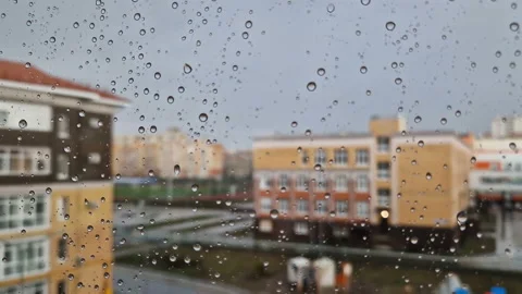 Heavy raindrops roll down the window pane. Stock Footage 214685545