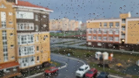 Heavy raindrops roll down the window pane. Stock Footage 217676956