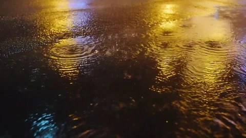 Heavy Raindrops Splashing in Puddle on City Asphalt at Night Vídeo Stock 337431668