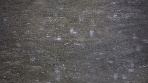 Heavy Raindrops Splashing on Wet Cement Ground Creating Large Bubbles. Stock Footage 336777539