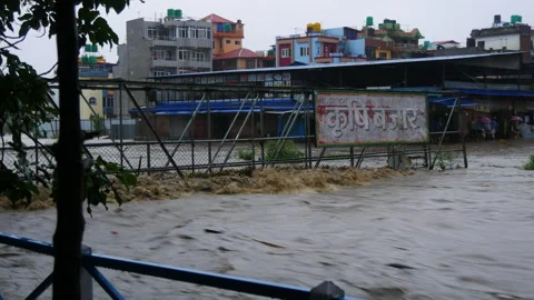 Heavy rainfall and muddy polluted flood water hitting an iron bridge Stock Footage 286015428