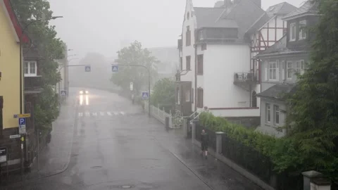Heavy Rainfall Creates a Tranquil Atmosphere on a Quiet Street Surrounded by Stock Footage 309250781