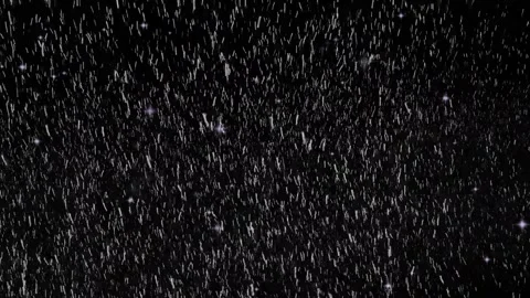 Heavy rainfall falling downwards against deep black background creating 스톡 동영상 342119877