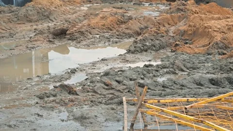 Heavy rainfall has created large puddles and muddy conditions on a construction Stock Footage 344675225