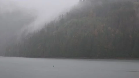 Heavy rainfall low clouds over lake Stock Footage 232799456
