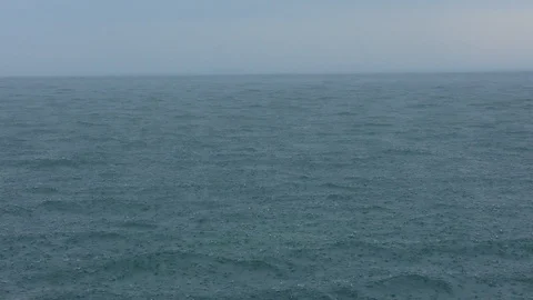 Heavy rainfall over the open sea creating ripples on the water surface Vidéo 90269403