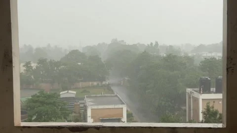 Heavy Rainfall Seen Through Window Over Urban Landscape in Daylight Video stock 340498904