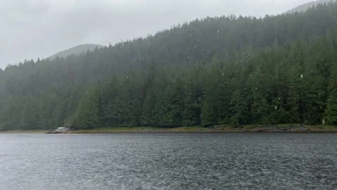 Heavy rainfall showers in the mountains hitting water in a bay, Roscoe Inlet Stock Footage 218404133