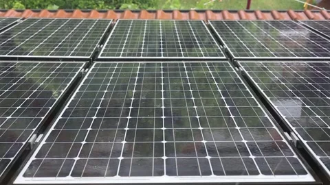 Heavy rainshower with big raindrops falling on a photovoltaic solar  Stock Footage 247111580