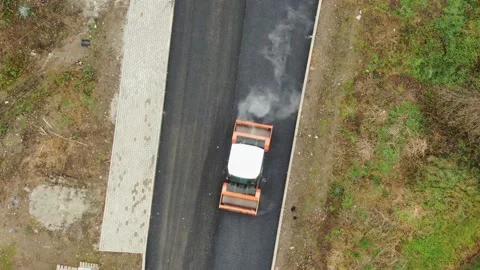 Heavy roller on road construction site pressing new asphalt layer aerial Stock Footage 236975165