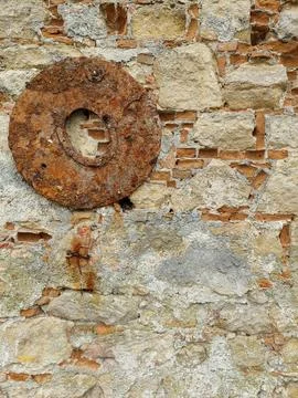 Heavy rusty metal ring on old rough stone and brick wall. Grunge texture Stock Photos