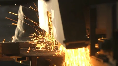 Heavy side grinder cutting a large metallic pipe with flying yellow sparkles Stock Footage 105450125
