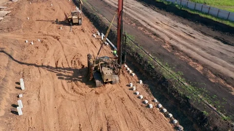 A heavy, small-sized drilling rig moves through the construction site. The Stock Footage 157644492