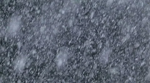 Heavy snow falling against black background Stock Footage 1084952