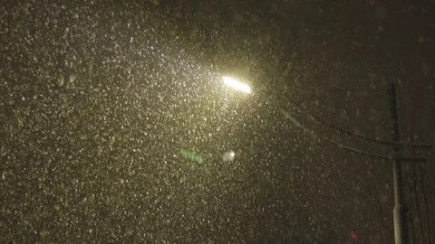 Heavy Snow Falling at Night Under Street Lamp Glow Stock Footage 339066828