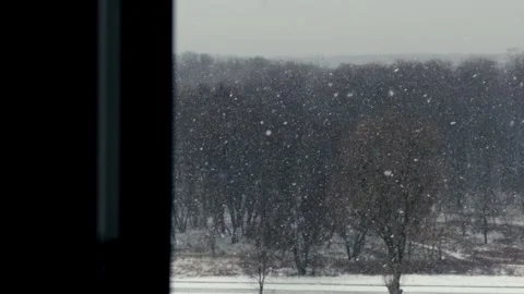 Heavy Snow Falling Outside a Window on an Overcast Day Stock Footage 325031940