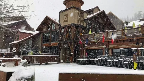Heavy snow falling over ski lift in Whistler Creekside village Vídeo Stock 127519037