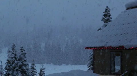 Heavy snow falling on a quaint cabin in the forest Stock Footage 1085180