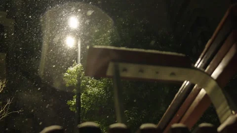 Heavy Snow Falls at Night Illuminated by Warm Street Lamp Видео 337409130