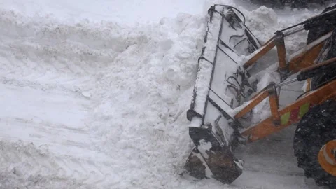 Heavy snow plow carving paths through thick winter accumulation Stock Footage 328089803